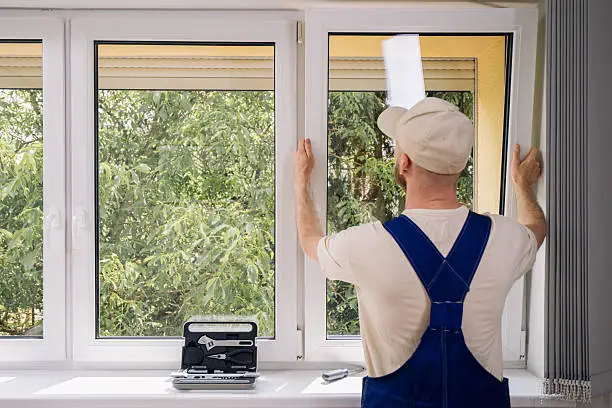 Installers fitting custom replacement windows on a detailed Hinsdale home exterior