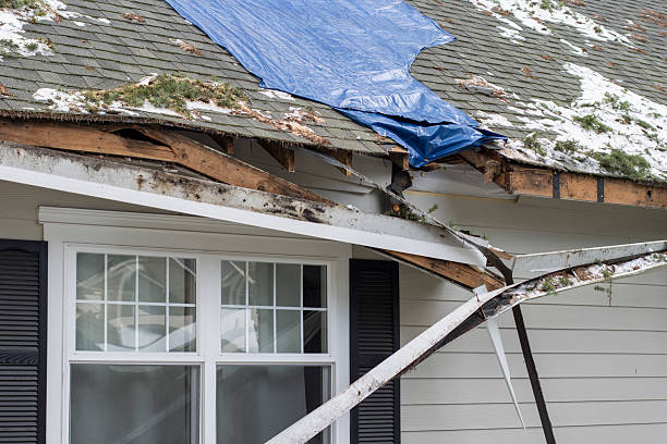 Roofers repairing wind-damaged shingles on a Hinsdale home after a storm