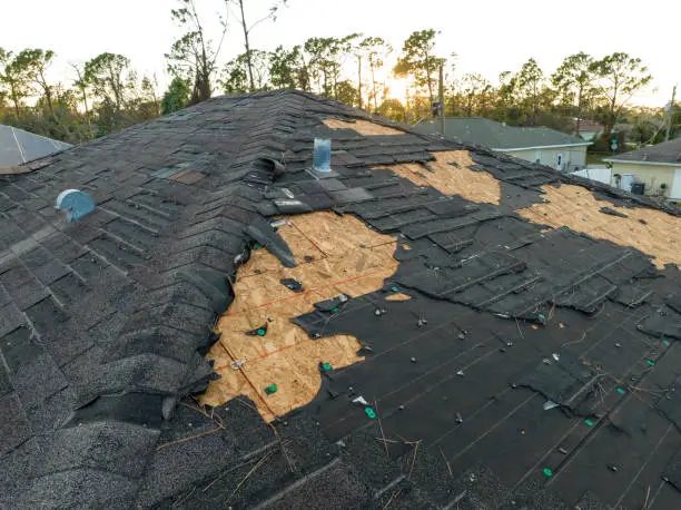 Crew repairing wind-damaged shingles on Chicago home after overnight summer storm